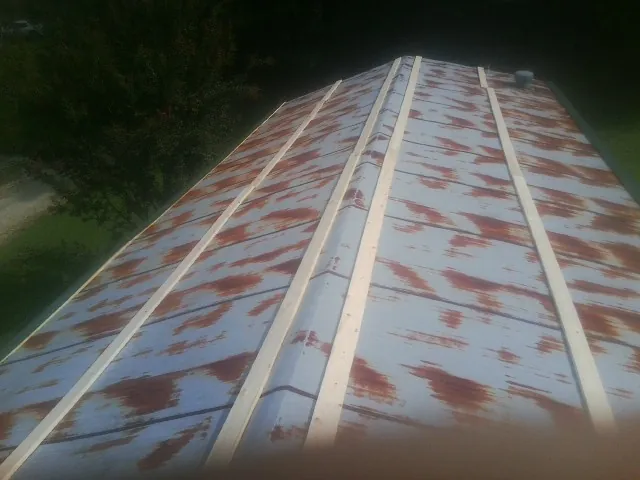 Rusted metal roof panels with new wood purlins before replacement — Storm Damage Roof Repair in La Salle by Roofing Brothers